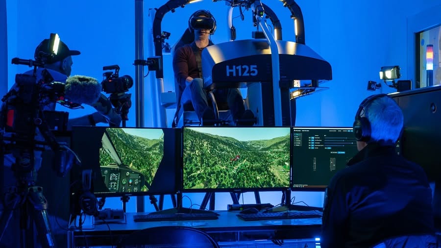 Ein Instruktor an der Instructor Operating Station, dahinter fliegt ein Pilot den H125-VR-Simulator